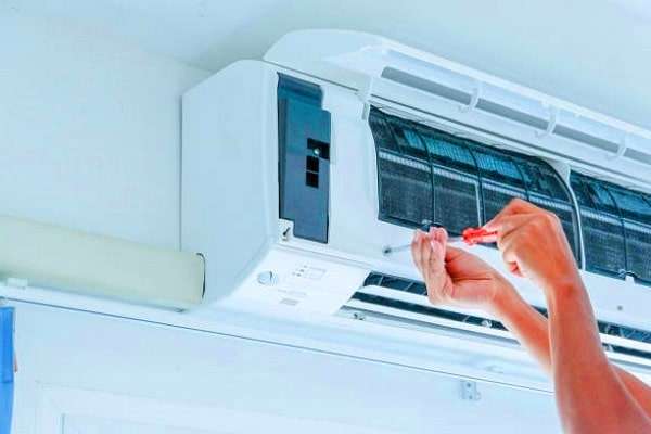 Technicien en climatiseur réparant un système de climatisation